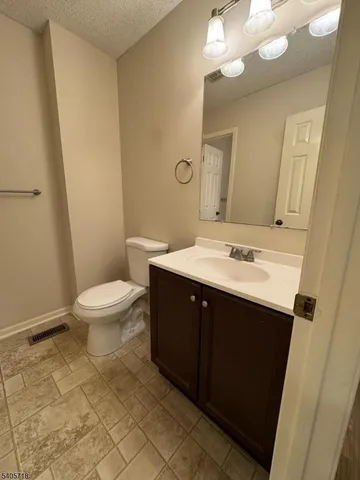 a bathroom with a sink mirror vanity and toilet