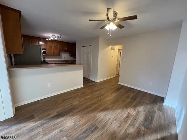 a living room with hard wood floors and a kitchen