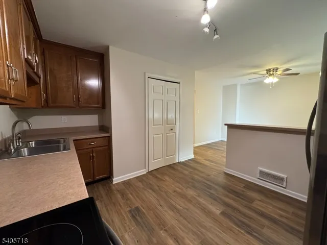 a view of a kitchen with a sink cabinets wooden floor and window