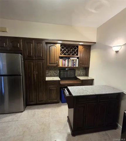a kitchen with stainless steel appliances granite countertop a refrigerator and a stove