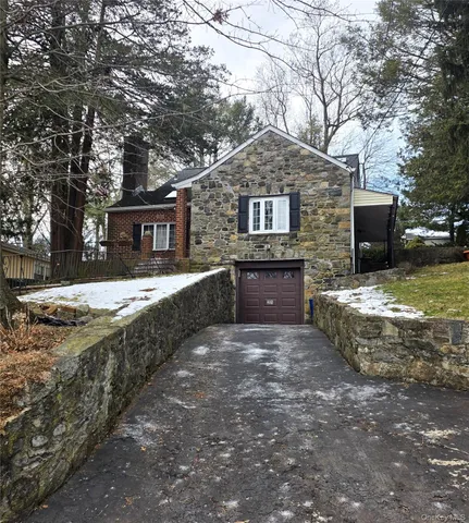 a front view of a house with yard and tree