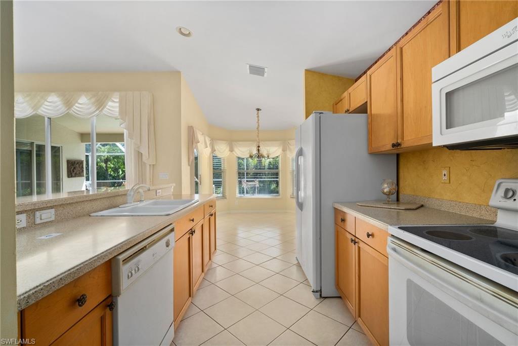 9281 Lanthorn Way Estero, FL 33928 - Photo 6 of 30 a kitchen with stainless steel appliances granite countertop a sink and a refrigerator