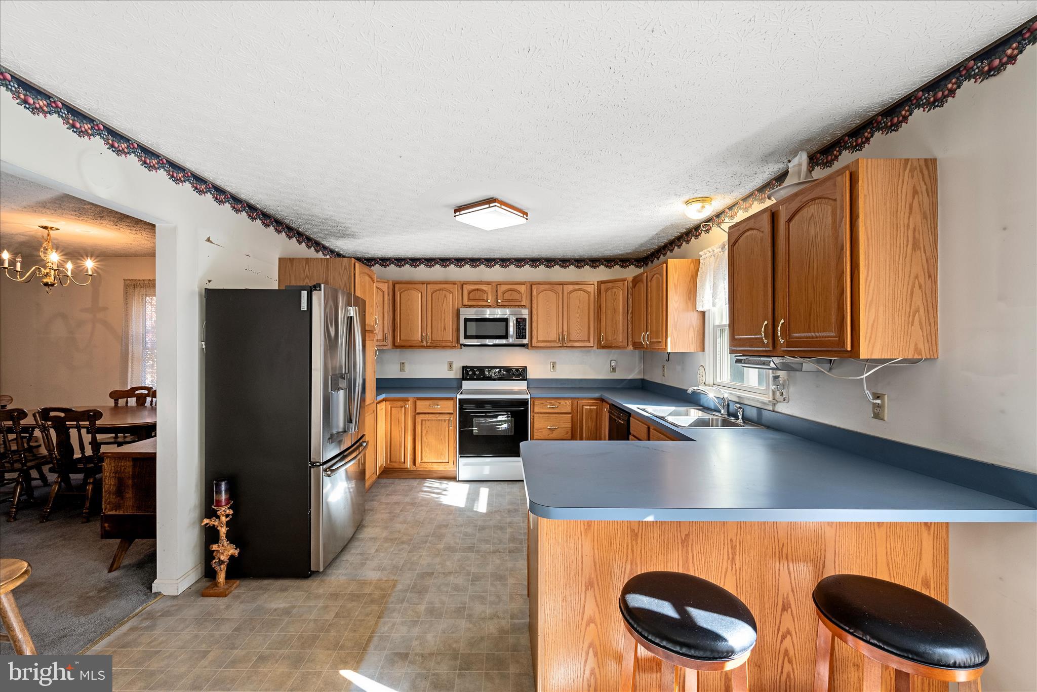 4403 Back Mountain Road Winchester, VA 22602 - Photo 5 of 73 a kitchen with stainless steel appliances granite countertop a refrigerator a stove and a sink with wooden cabinets