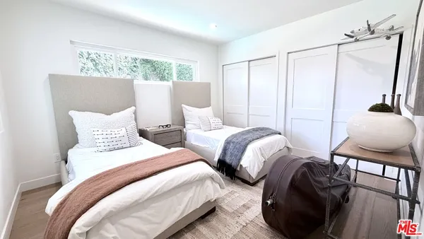 a bedroom with two beds and a dresser