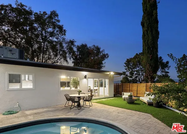 a view of a house with backyard sitting area and garden
