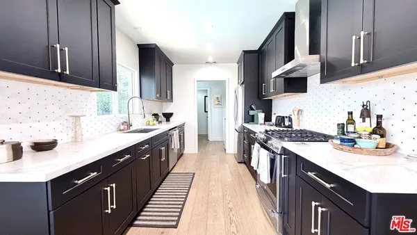 a kitchen with stainless steel appliances granite countertop a sink stove and cabinets