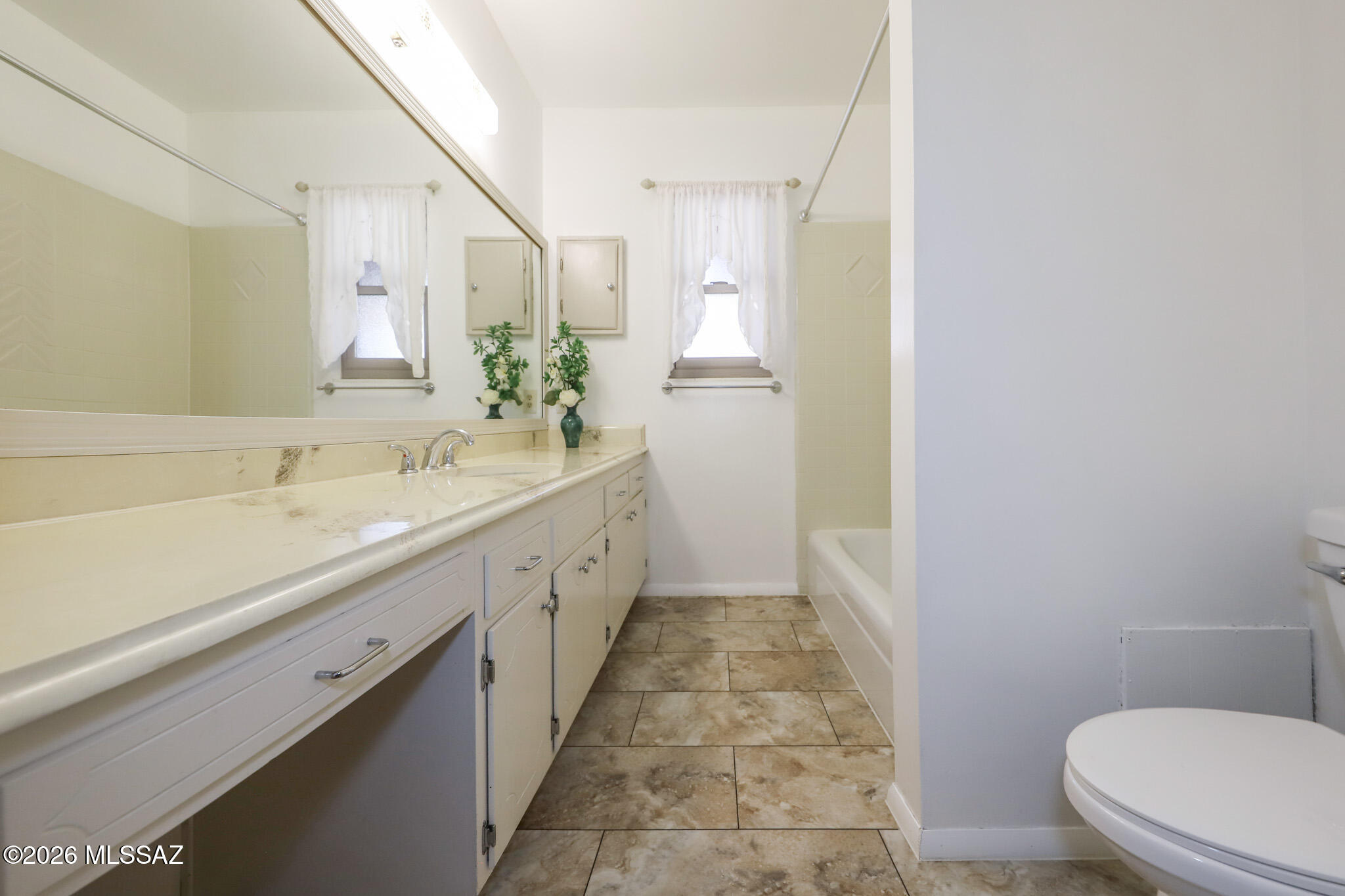 37 North Silverbell Road Tucson, AZ 85745 - Photo 21 of 31 a spacious bathroom with a double vanity sink toilet and a mirror