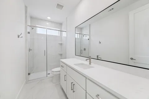 a bathroom with a sink a toilet and shower