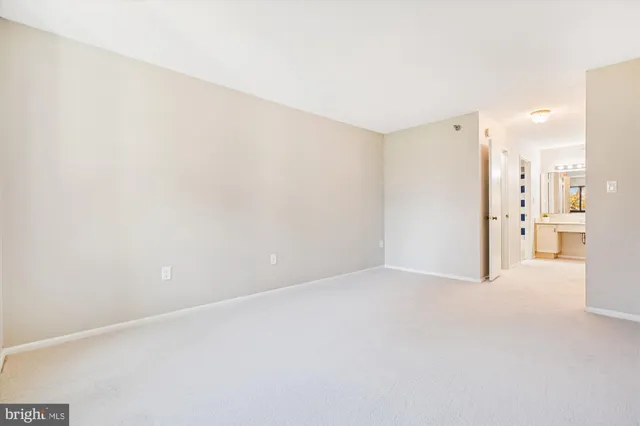 a view of a kitchen with an empty space and a refrigerator