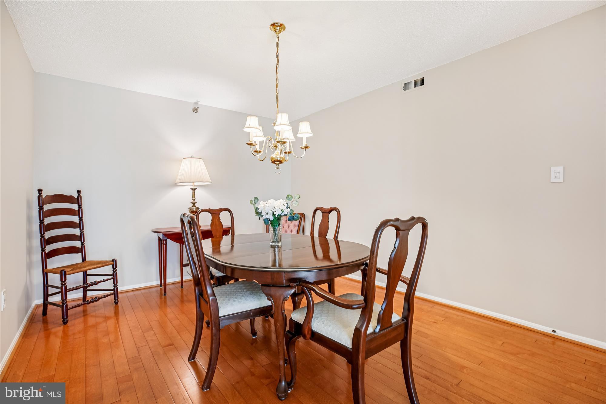 15115 Interlachen Drive, Unit 3308 Silver Spring, MD 20906 - Photo 7 of 50 a dining room with furniture wooden floor a rug and a chandelier