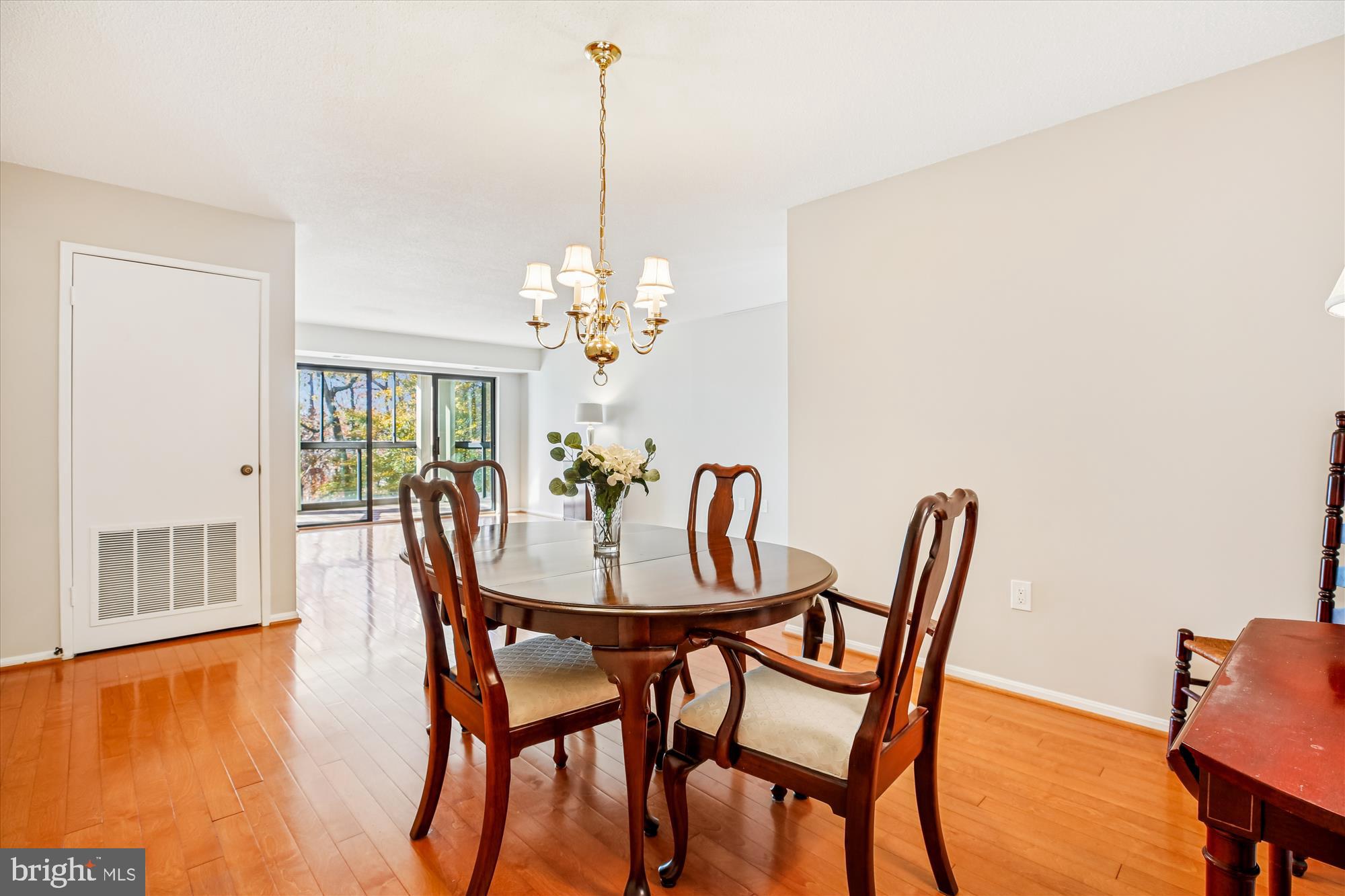 15115 Interlachen Drive, Unit 3308 Silver Spring, MD 20906 - Photo 8 of 50 a view of a dining room with furniture a chandelier and wooden floor