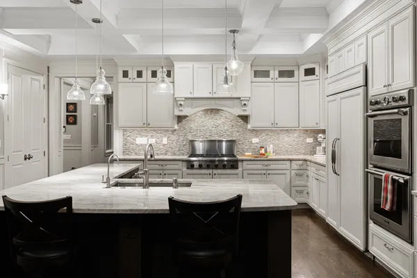 a kitchen with kitchen island granite countertop a sink cabinets and stainless steel appliances