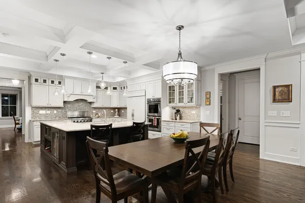 a view of a dining room and livingroom with furniture wooden floor a chandelier