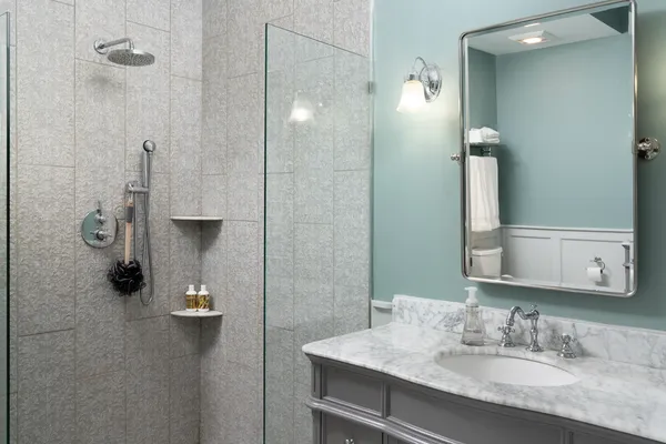 a bathroom with a sink shower and a mirror