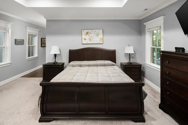 a bed sitting in a bedroom next to a window with a dresser