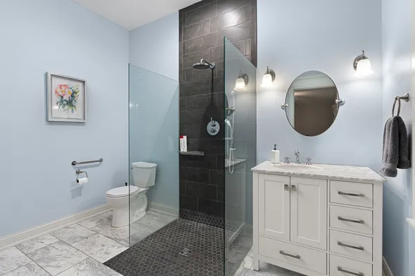 a bathroom with a toilet a sink and mirror