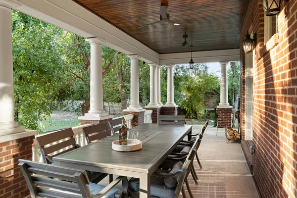 a view of a patio with table and chairs and floor to ceiling window