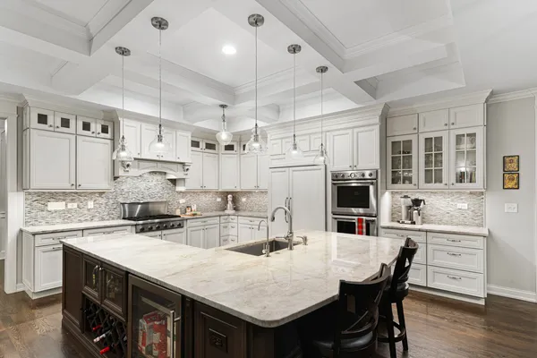 a kitchen with stainless steel appliances granite countertop a kitchen island a stove a table and chairs