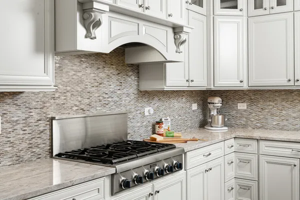a kitchen with granite countertop white cabinets and white appliances