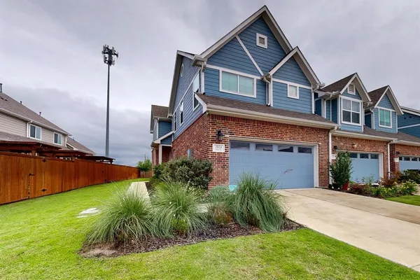 a front view of a house with a yard and potted plants