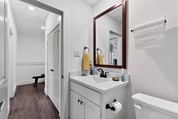 a bathroom with a sink a toilet a mirror and shower