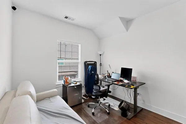 a view of a workspace with furniture and a window