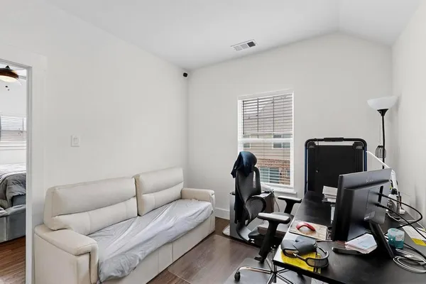 a living room with furniture a flat screen tv and a window