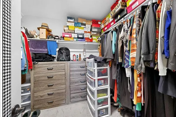 a view of walk in closet with clothes and shoes