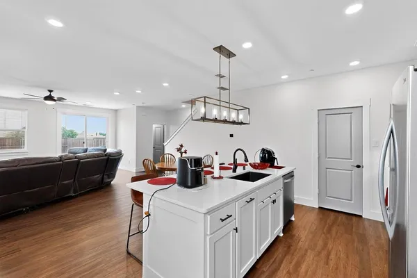 a kitchen that has a lot of cabinets and wooden floor