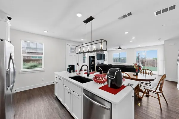 a kitchen with stainless steel appliances granite countertop a sink a stove and a refrigerator