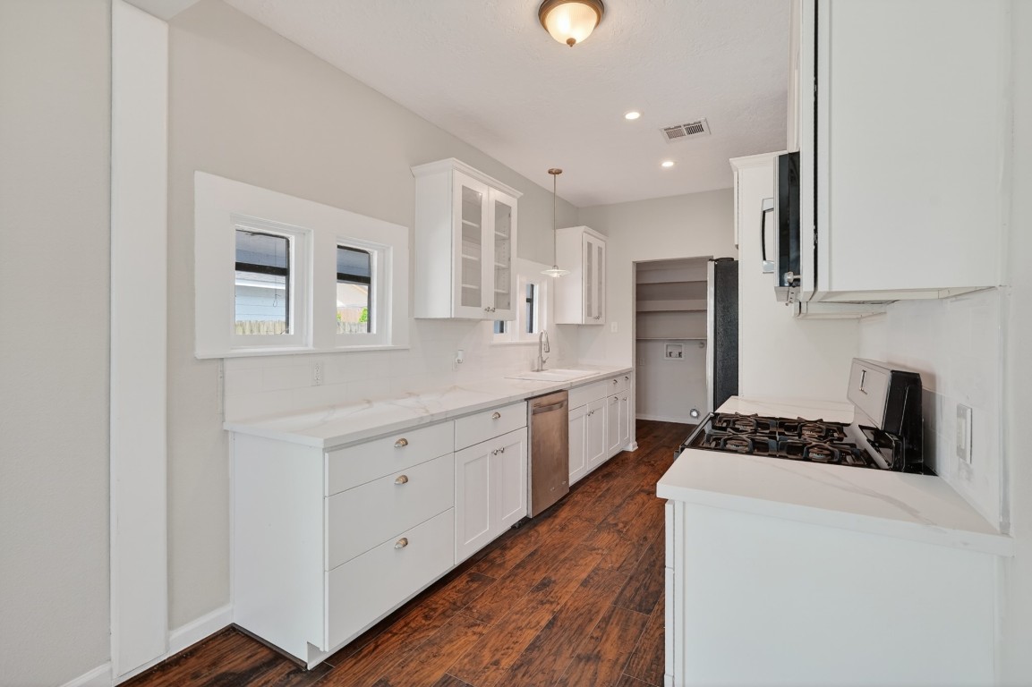 5401 North Capitol Street Houston, TX 77011 - Photo 22 of 39 a kitchen with white cabinets and stainless steel appliances