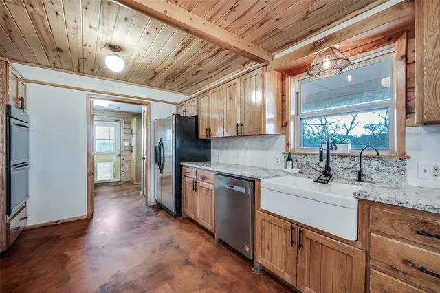 a large kitchen with stainless steel appliances granite countertop a sink stove and cabinets