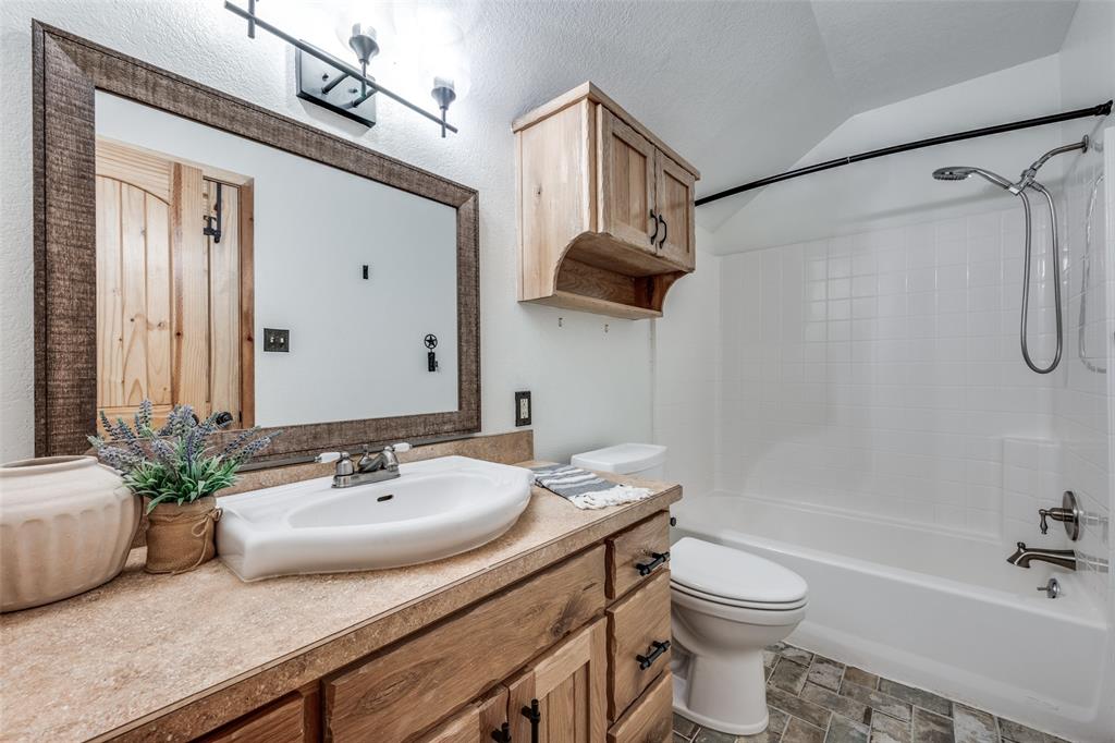 1353 Spring Creek Road Collinsville, TX 76233 - Photo 26 of 40 a bathroom with a sink a toilet and shower