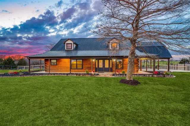 a view of a house with backyard and a tree