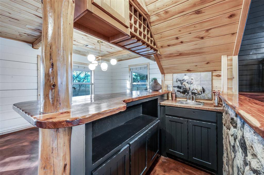 1353 Spring Creek Road Collinsville, TX 76233 - Photo 10 of 40 a kitchen with a sink and wooden cabinets