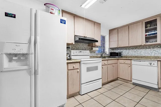 a kitchen with white cabinets and white appliances
