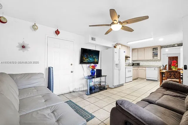 a living room with furniture and white kitchen