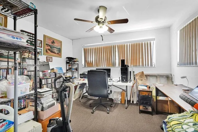 a room with chandelier fan and windows