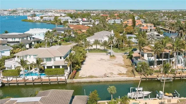 an aerial view of residential houses with outdoor space and lake view