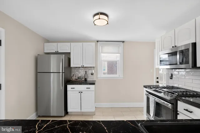 a kitchen with stainless steel appliances granite countertop a refrigerator stove and sink
