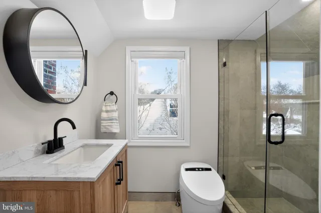 a bathroom with a toilet a sink and mirror