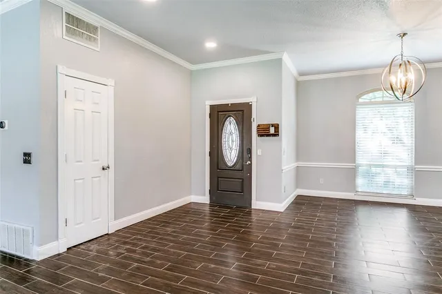 a view of empty room with wooden floor and window