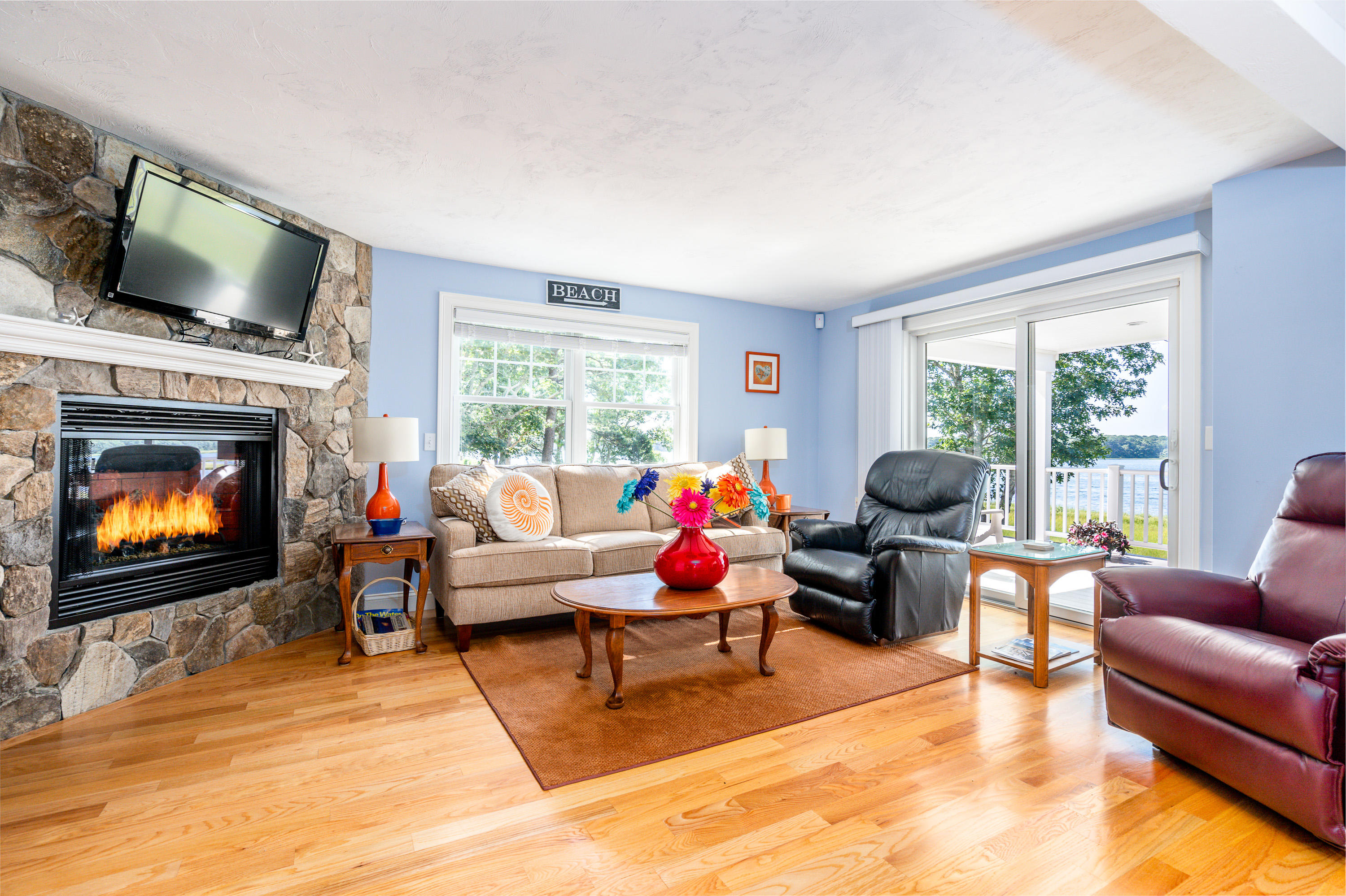 17 Monomoscoy Road West Mashpee, MA 02649 - Photo 8 of 36 a living room with furniture a fireplace and a flat screen tv
