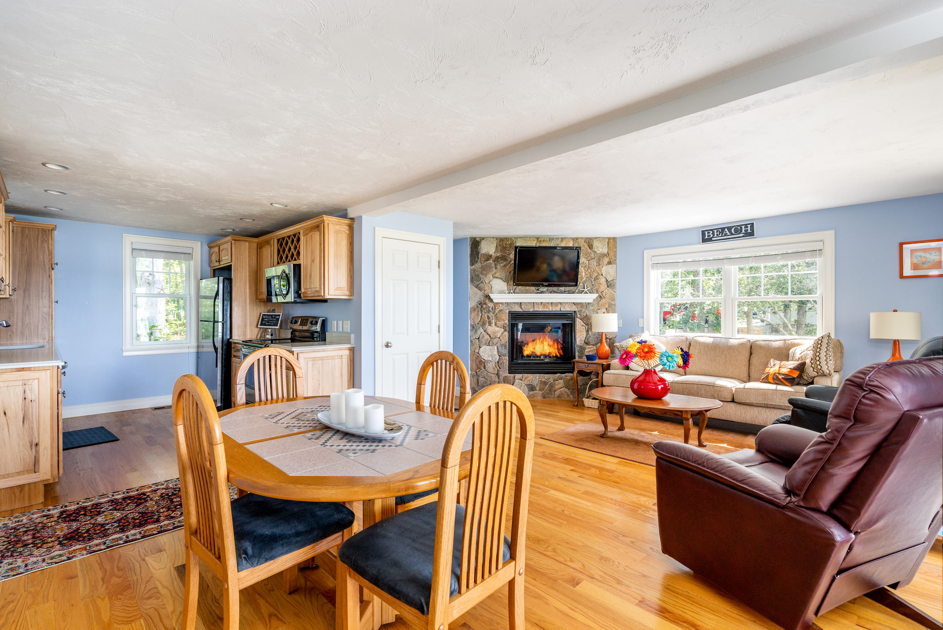 17 Monomoscoy Road West Mashpee, MA 02649 - Photo 10 of 36 a living room with furniture a fireplace and a flat screen tv
