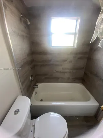 a bathroom with a sink and bathtub with toilet