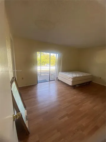 a view of a room with wooden floor and window