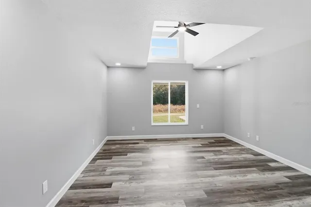 a view of a hallway with wooden floor and a bathroom