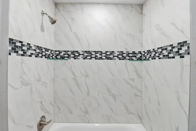 an empty room with a window and ceiling fan