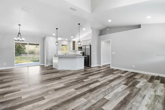 a view of a kitchen with wooden floor and a window