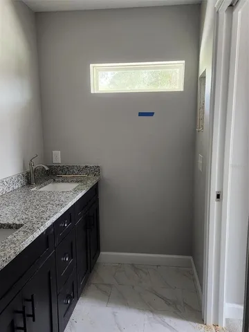 a bathroom with a granite countertop sink and vanity